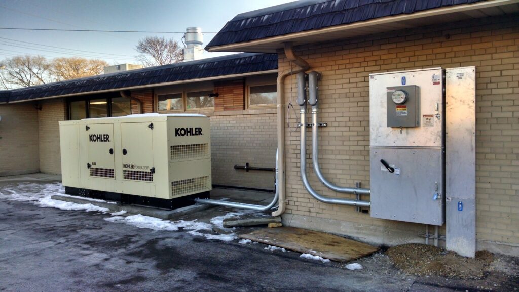 A Kohler generator and electrical panels installed on the exterior of a building by Valiant Electric Inc. in Kenosha, WI.