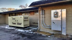 A Kohler generator and electrical panels installed on the exterior of a building by Valiant Electric Inc. in Kenosha, WI.