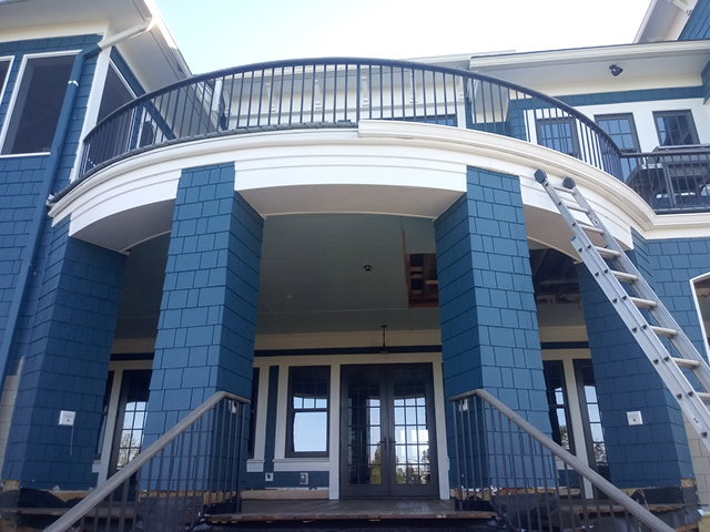 A ladder leaning against a house with blue siding, indicating exterior work by Charleston Exteriors in Charleston, SC.