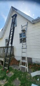 Two ladders leaning against a house, indicating exterior repair or maintenance work by SAM'S Handywork LLC in Independence, IA.