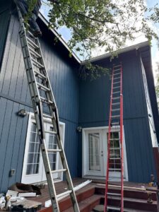 Two ladders leaning against a house with blue siding, indicating repair or maintenance work by Alaskan Residential Rescue in Anchorage, AK.