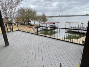 A newly installed lakefront deck with black metal railings, offering scenic views, completed by Falls Contracting, LLC in Raleigh, NC.
