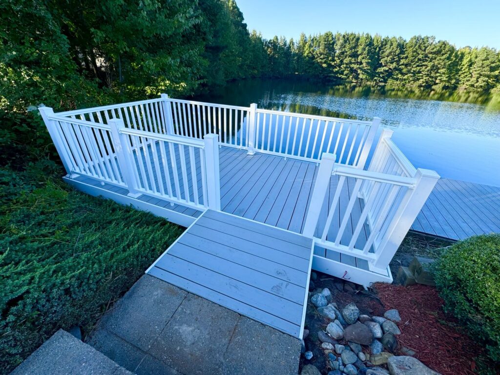 Beautiful lakeside composite deck with white railings installed by BOS HOME Exterior Services in Virginia Beach, VA
