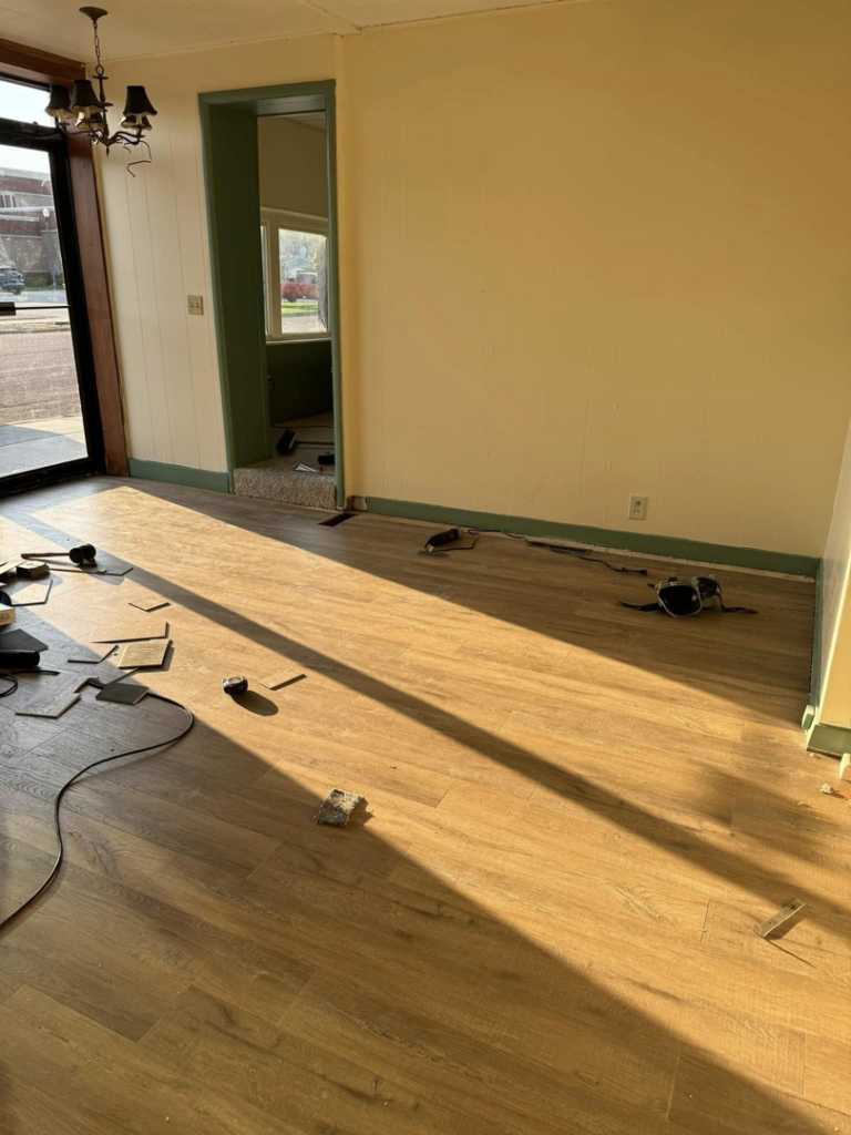 Laminate flooring installation in progress in a commercial space by Wheeler's Handyman Services in Vermillion, SD