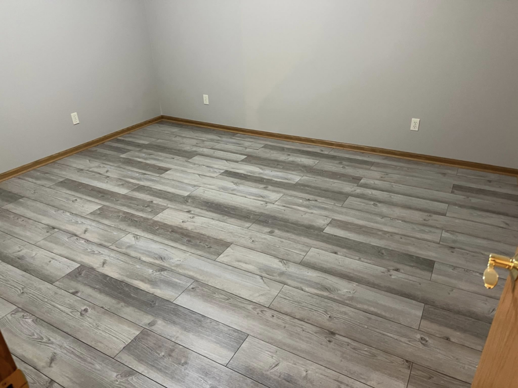 New grey wood-look laminate flooring installed in a room by Halls Home Solutions in Pierre, SD