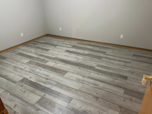 New grey wood-look laminate flooring installed in a room by Halls Home Solutions in Pierre, SD