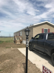 Newly installed lamppost with house numbers and wooden steps by Devotion Construction LLC in Pierre, SD.