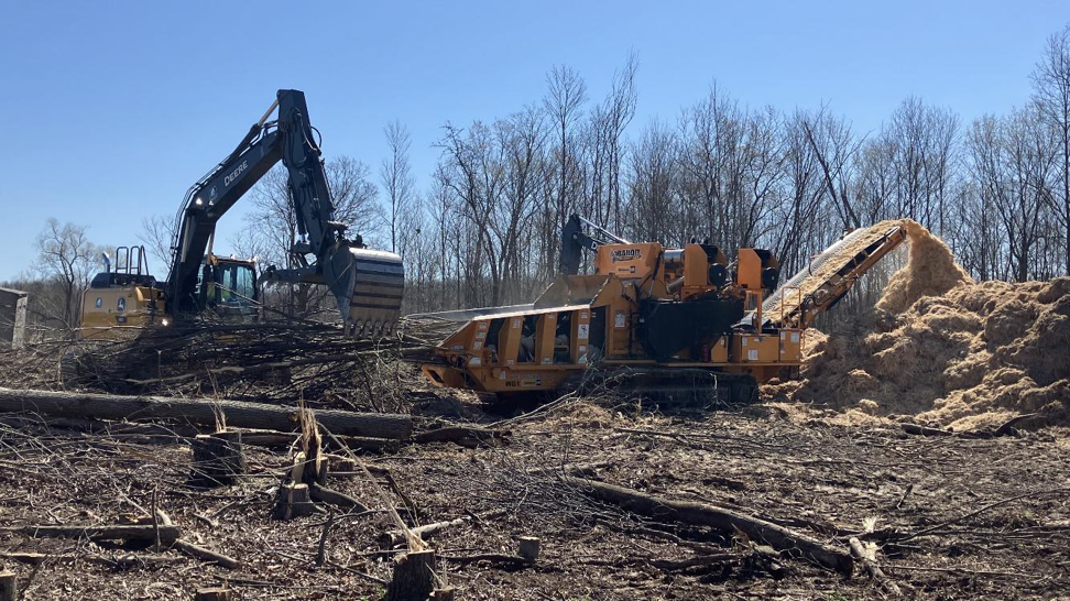 Land clearing with an excavator and wood chipper by Upper Cut Tree Service, LLC in Williamston, MI