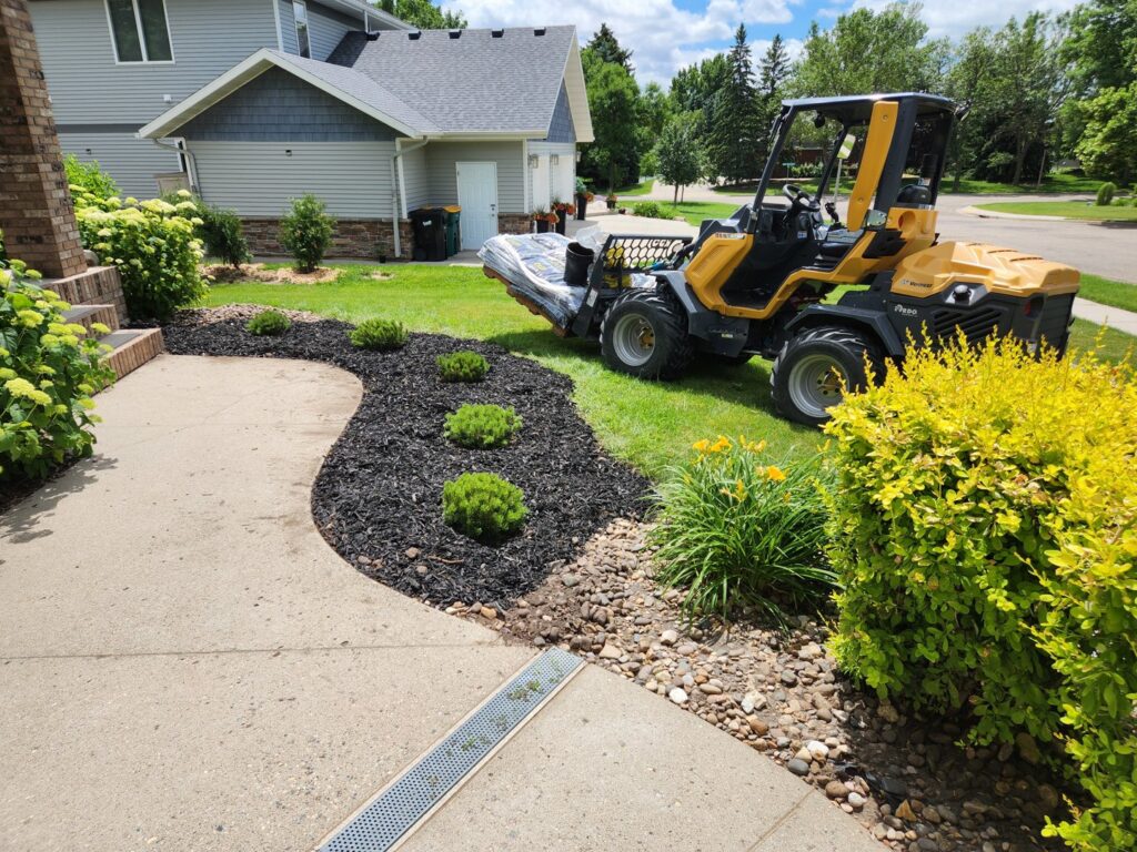 A small loader working on a residential landscaping and planting project by Tree Rows 4 U in Bismarck, ND.