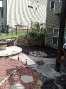Landscaping and patio work in progress at a home, provided by Mels Haul & Junk Removal in Raleigh, NC.