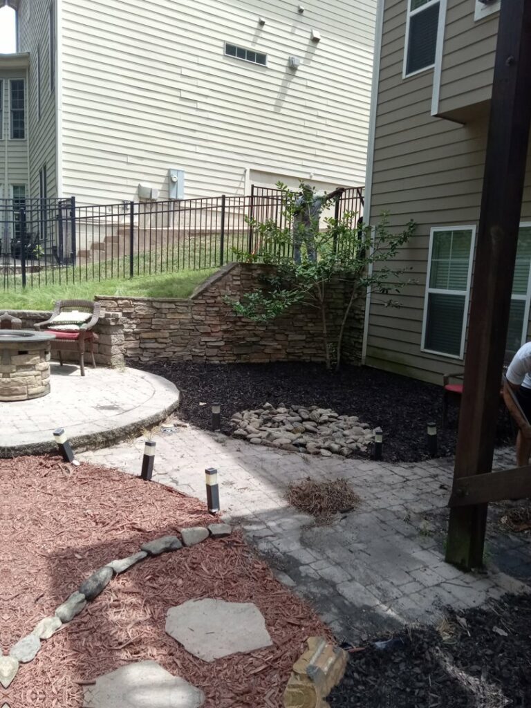 Landscaping and patio work in progress at a home, provided by Mels Haul & Junk Removal in Raleigh, NC.