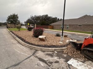 A landscaping project with rock installation and a skid steer by R and R contractors in Rogers, AR.