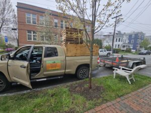 A landscaping truck loaded with pallets and towing a U-Haul trailer, demonstrating vehicle outfitting for work by Handyman Vehicle Outfitters in Portland, ME.