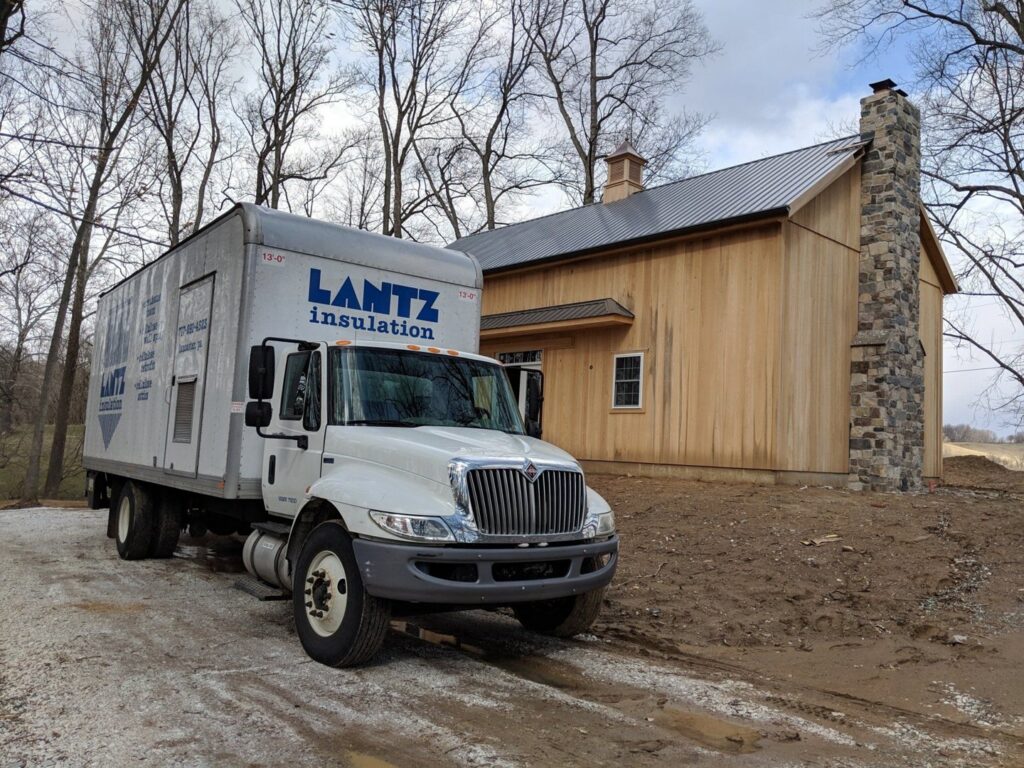A Lantz Insulation Inc truck parked at a construction site with a new wooden building in Bird In Hand, PA.