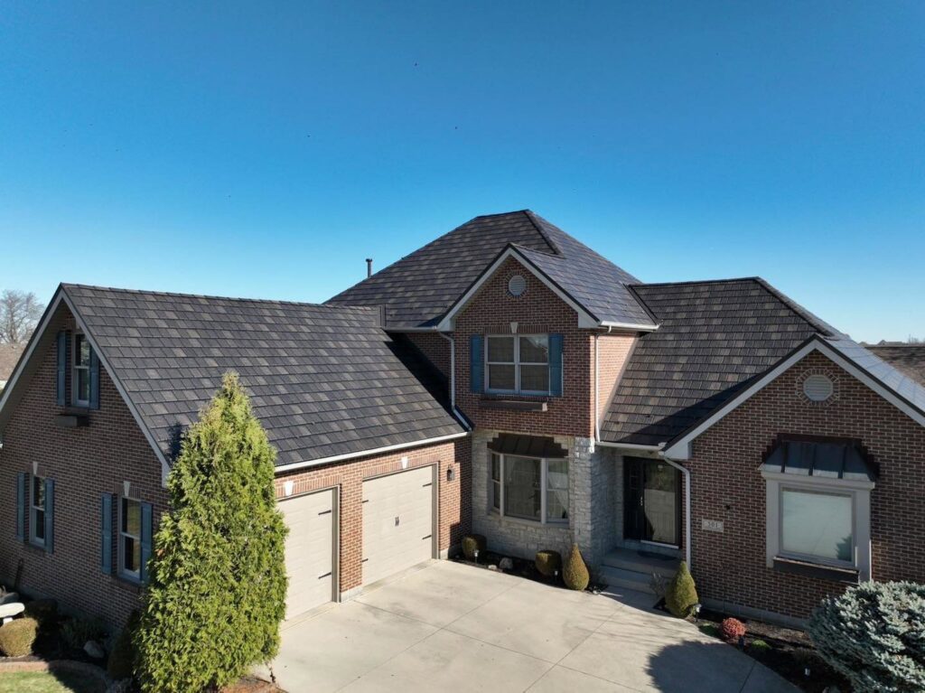 A large brick house featuring a newly installed dark shingle roof by Keep It Simple Construction LLC in Woodburn, IN.