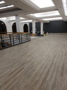 A large commercial space with newly installed laminate plank flooring by JMQ Contractor INC in Philadelphia, PA