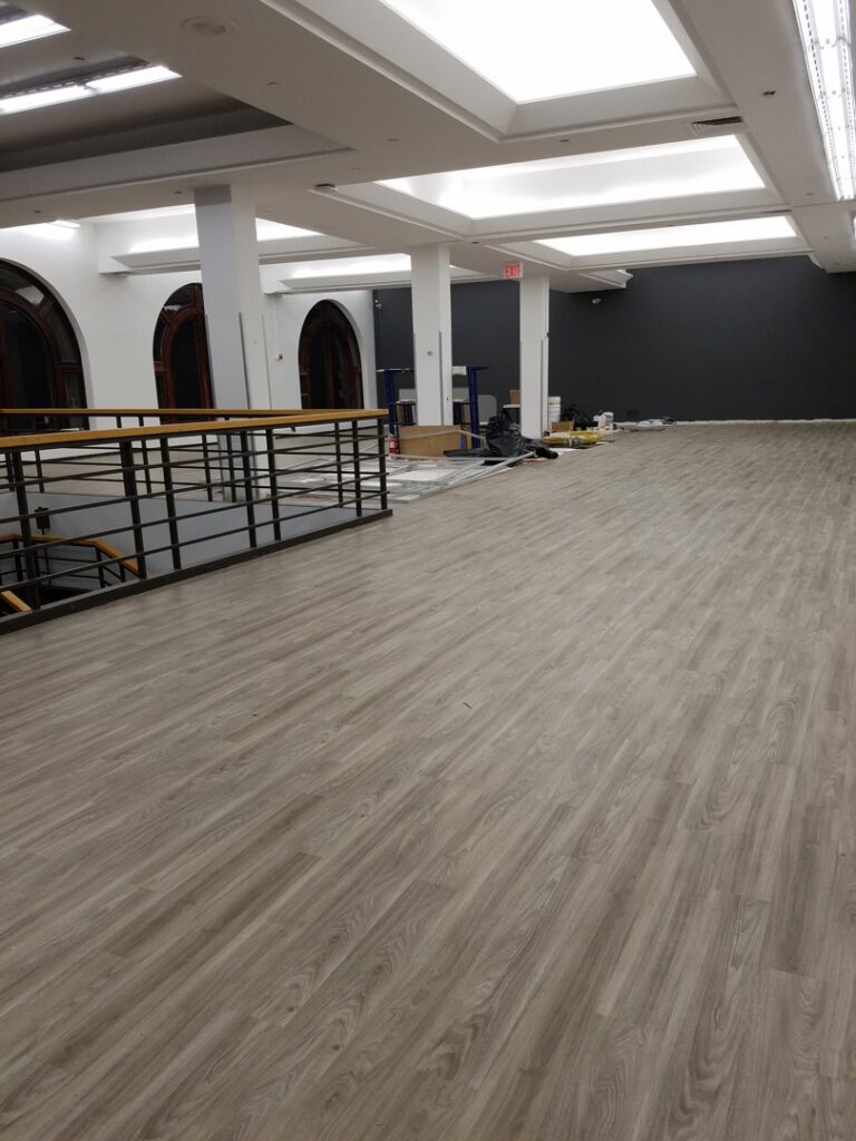 A large commercial space with newly installed laminate plank flooring by JMQ Contractor INC in Philadelphia, PA