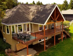 A large, elegant composite deck featuring a covered section and sturdy railing, expertly built by Ridgeline Decks in Spokane, WA.