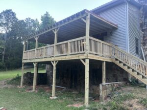 A large, newly constructed covered wooden deck attached to a house, built by Hill Renovations LLC in Athens, GA