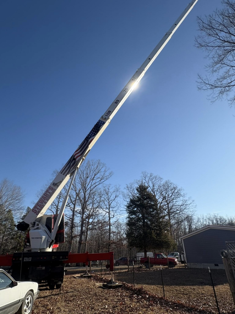 A large crane with an extended boom, used for tree removal by MacNeela's Tree Service in Durham, NC