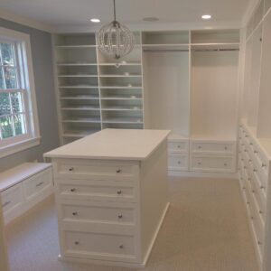 A spacious custom walk-in closet with an elegant central island installed by Closet Creations Inc. in Sleepy Hollow, NY.