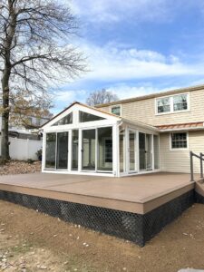 A large outdoor deck connected to a new sunroom addition, expertly constructed by RW Contracting Phila, LLC in Philadelphia, PA.
