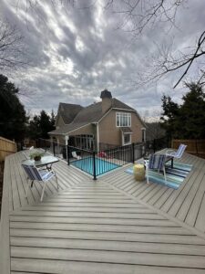 A large deck surrounding a swimming pool with safety fencing, constructed by Deckscape KC in Kansas City, MO.
