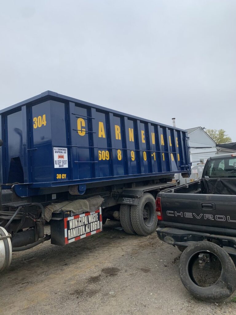 A large blue AJ Carnevale Disposal dumpster on the back of a truck in Hamilton, NJ