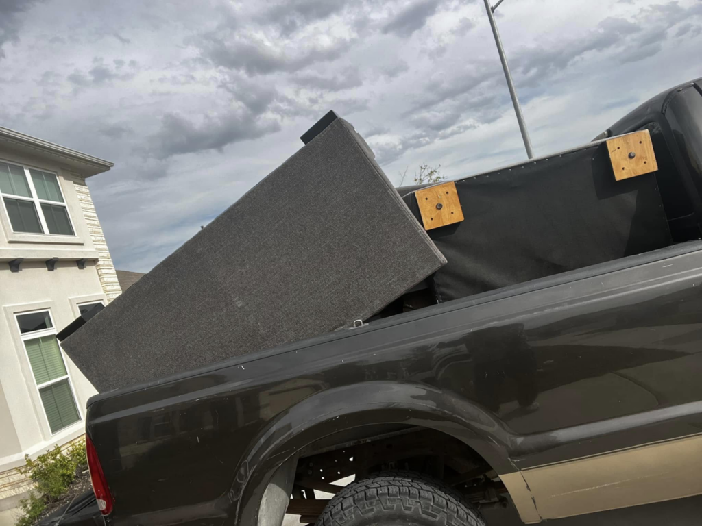 A large furniture item being loaded onto a pickup truck for removal by ONLY Junk Removal Services in Austin, TX.