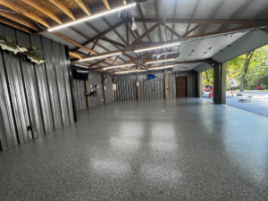A spacious garage or workshop featuring a new grey speckled epoxy floor coating by 812 Concrete Coatings in Evansville, IN.