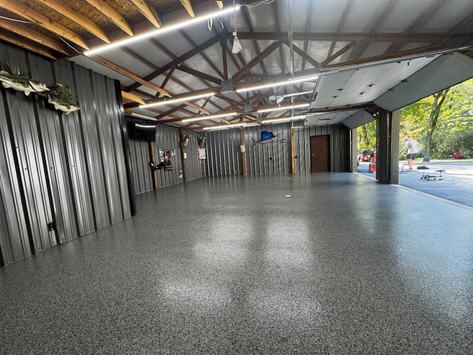 A spacious garage or workshop featuring a new grey speckled epoxy floor coating by 812 Concrete Coatings in Evansville, IN.