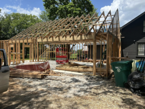 A large garage or extension under construction, showing the framing and roof trusses by Old Things Created New Handyman Service in Springdale, AR.