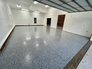 A spacious garage with a newly applied speckled floor coating by Garage Upgrade Pros in Fort Mill, SC.