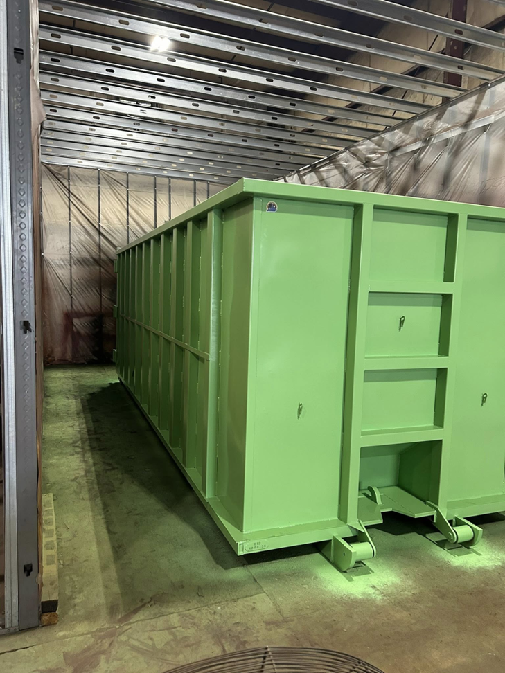 A large green roll-off container ready for junk removal services by Eagle Industrial Solutions in Louisville, KY.