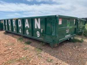 A large green roll-off dumpster with 'JORDAN' branding from Jordan Disposal, LLC in Galena, KS, ready for junk removal.