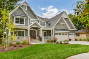 A large grey house with a welcoming wrap-around porch, a completed project by Autumn Homes in Naperville, IL.