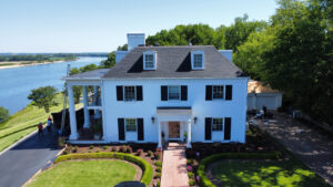 An aerial view of a large white house with a new dark shingle roof, completed by Northcross Restoration Inc in Memphis, TN.