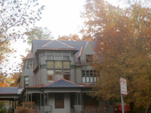 The exterior of a large house showcasing a new slate roof and copper accents by Copper & Slate Inc. in Buffalo, NY