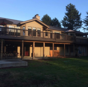 A large house featuring an expansive multi-level deck, showcasing exterior construction by Kalau Builders LLC in Eugene, OR.