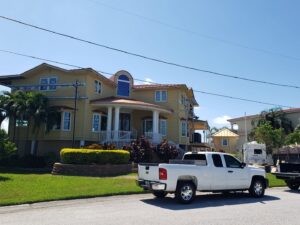 A large house undergoing exterior renovation with scaffolding, showcasing work by Alejandro Melo Contractor corp in Tampa, FL.