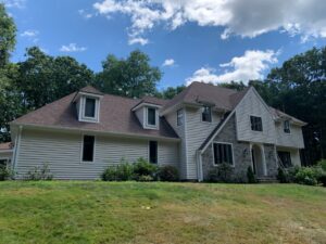 A large house showcasing a completed siding and roofing project by Bartlett Brainard Products Co. in West Hartford, CT.