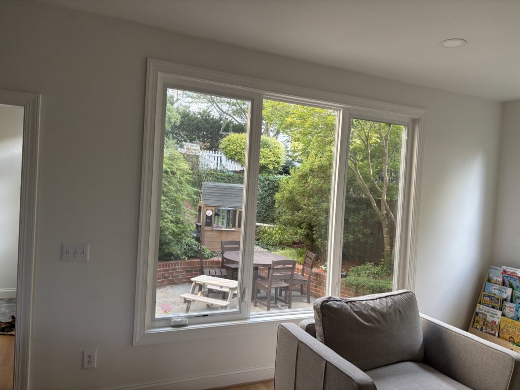 A large interior window offering a view of a backyard, installed by NC Siding and Windows in Raleigh, NC