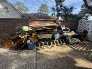A massive pile of mixed junk, including cardboard, trash bags, and debris, awaiting removal during a yard cleanout by L.P.Z Trash & Junk Removal in Tallahassee, FL.
