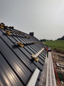 Large metal roof installation in progress with scaffolding by JB Home Improvement Services in Sanford, FL.