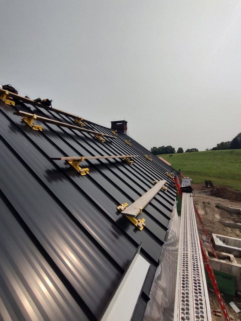 Large metal roof installation in progress with scaffolding by JB Home Improvement Services in Sanford, FL.