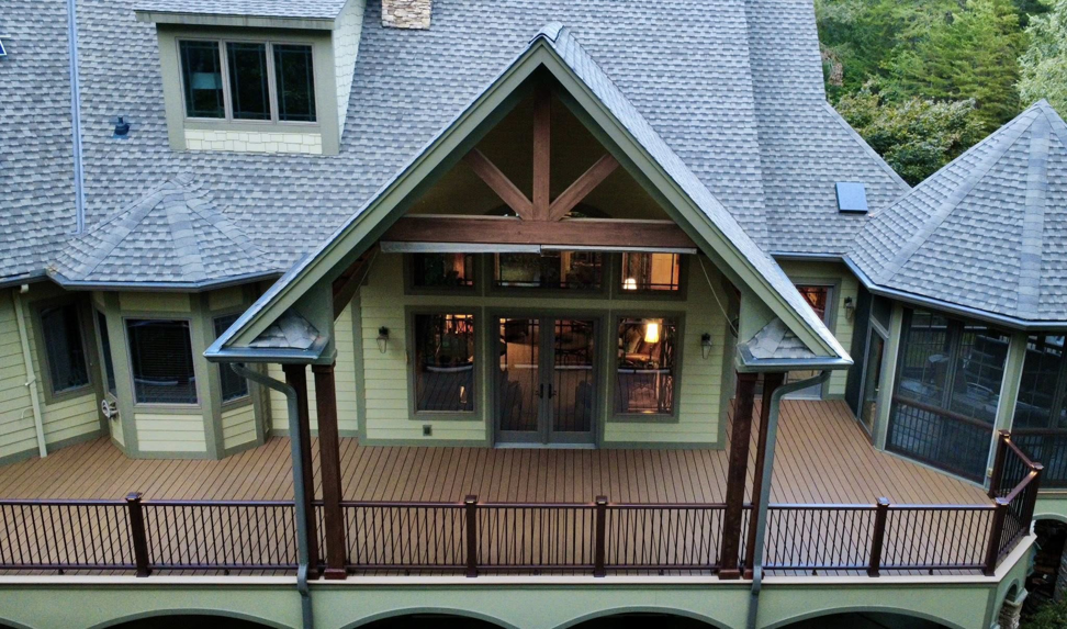 An aerial view of a large, multi-level deck with railings attached to a residential home, built by RJS Custom Decks in Cibolo, TX.