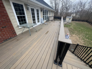 A large outdoor composite deck installation with black railing by Decks Unlimited, a handyman service in Littleton, CO.