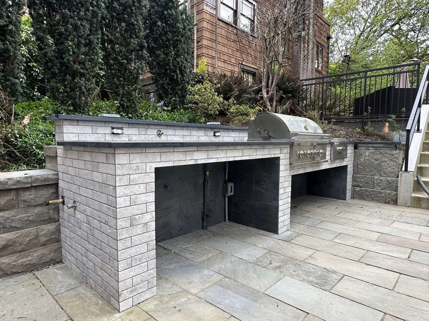 A large outdoor kitchen and bar area with built-in grill installed by Eagle Outdoor Living LLC in Freeland, WA.