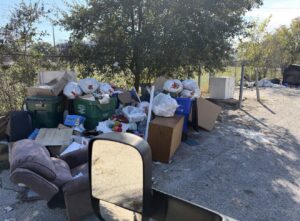 A large outdoor pile of various junk items, including trash bags and furniture, awaiting removal by Junk Out Boyz LLC in Georgetown, TX.