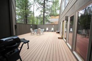 A spacious outdoor wooden deck with patio furniture and a grill by Winch Construction in Bend, OR.